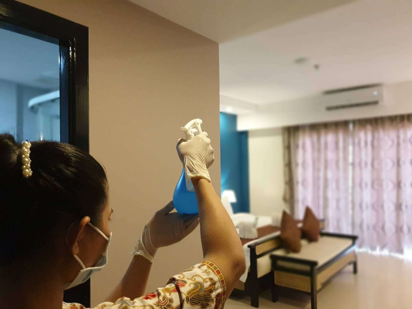 A person cleaning a room with a spray bottle.