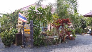 Um resort tropical com uma placa indicando 'SUMMER HOUSE' e 'FUN GARDEN'.