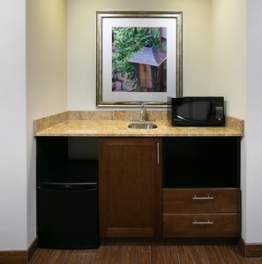 A kitchenette with a framed picture, a sink, a microwave, and a dishwasher. - Hilton Garden Inn Bettendorf/ Quad Cities (Bettendorf)