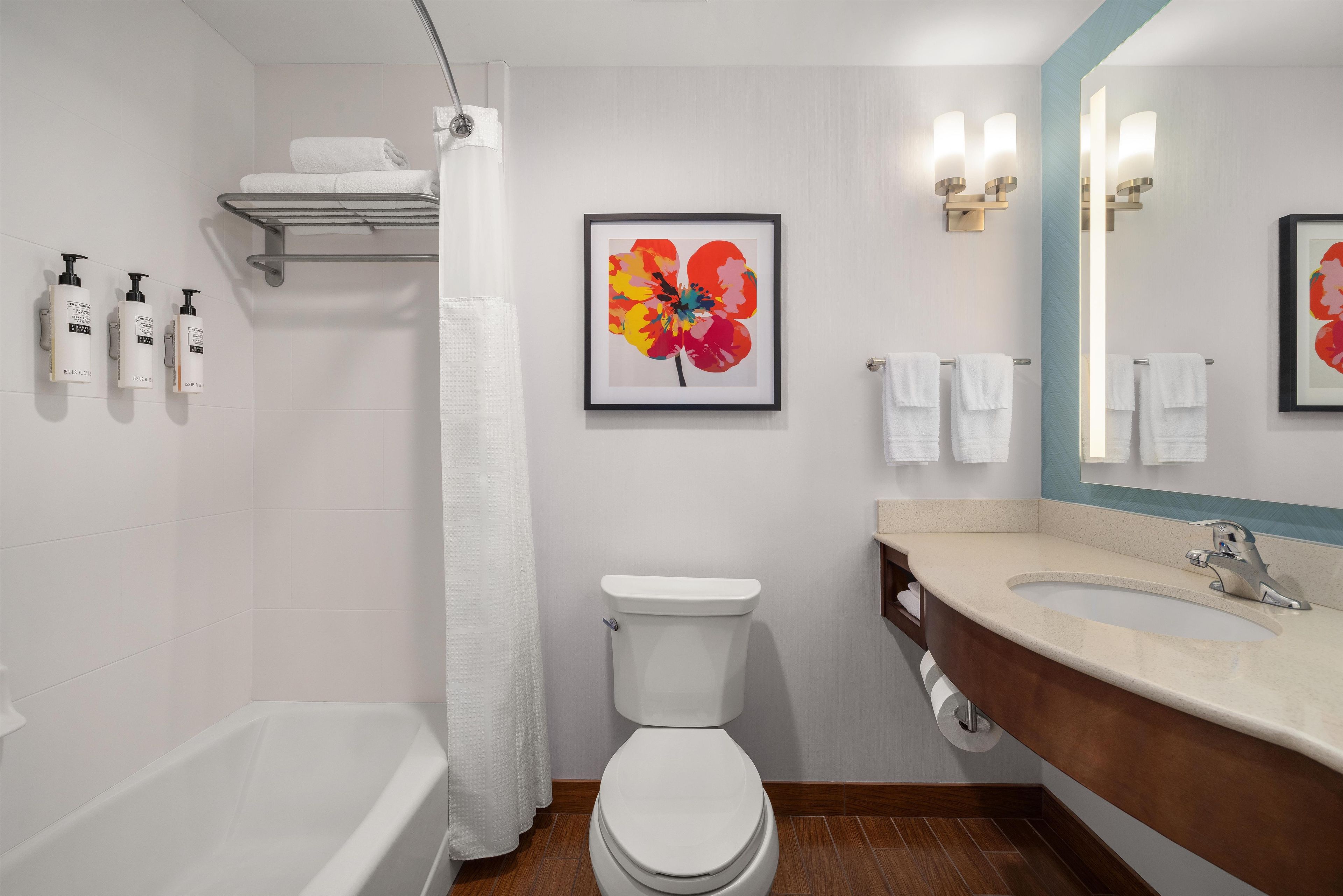 Un baño con bañera, inodoro, lavabo y cortina de ducha.