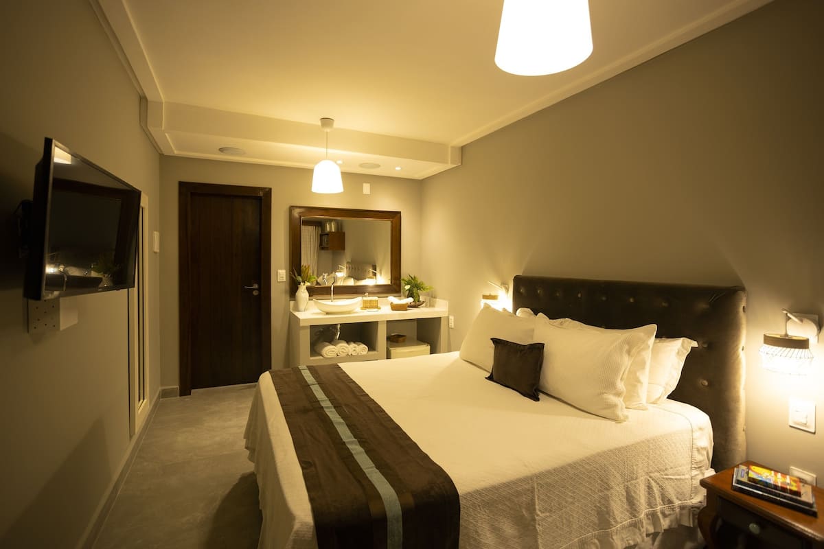 Suite Economy, edificio separato (Piso Térreo) | 1 camera, minibar, una cassaforte in camera, tende oscuranti