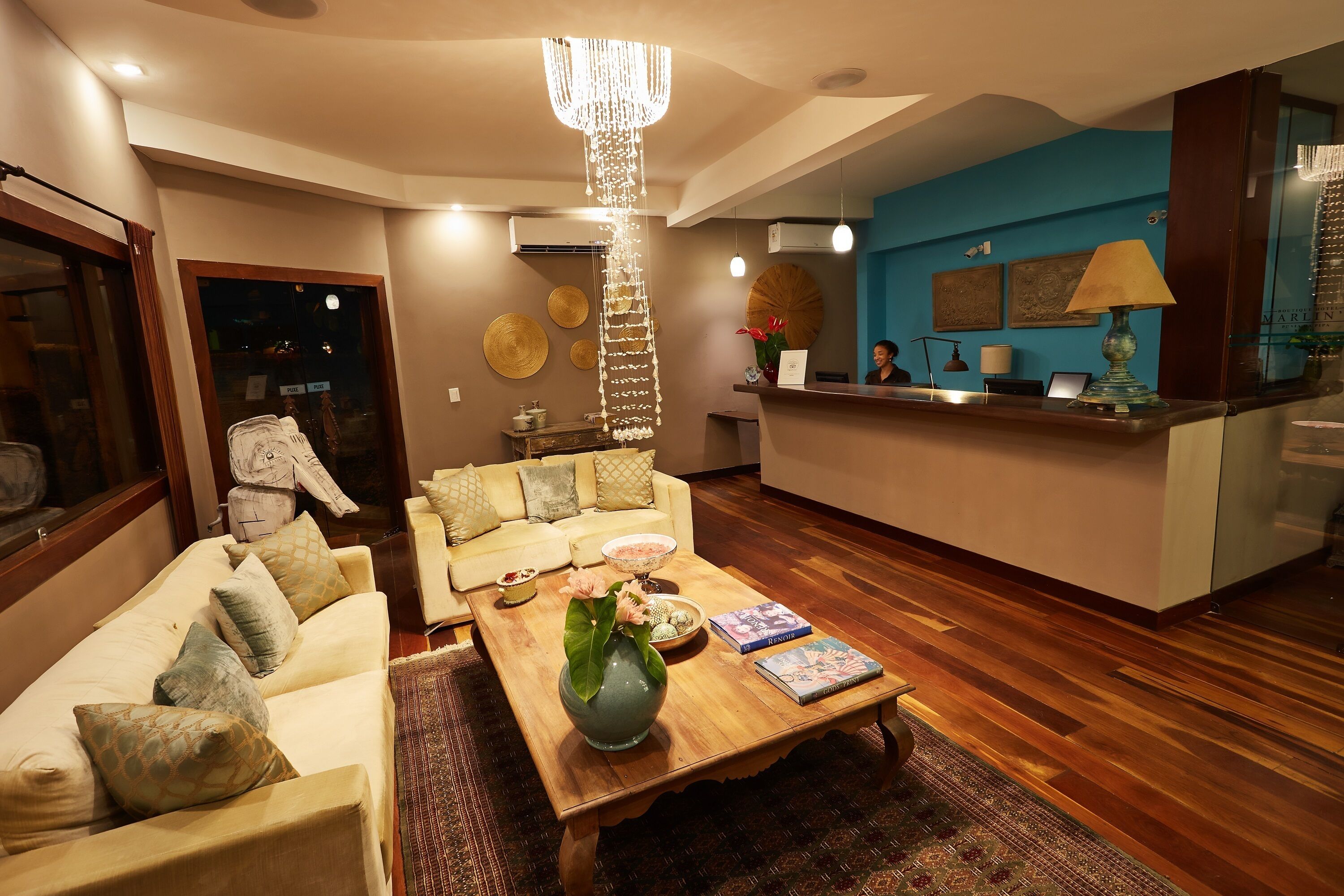 A modern living room with a wooden coffee table, a white sofa, and a chandelier.