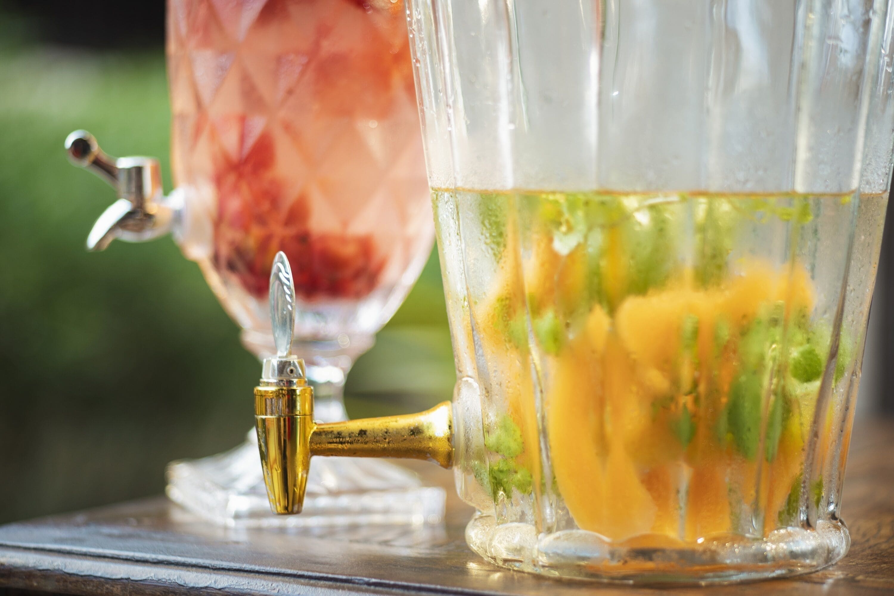 A clear glass teapot with a gold spout and handle, placed on a wooden surface.