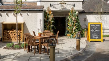 A wooden table and chairs outside a building with a sign reading "Himley House".