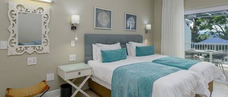 A bedroom with a large bed, a bedside table, a chair, and a window with a view of the outdoors.