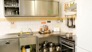 A modern kitchen with stainless steel appliances, a sink, and a variety of pots and pans. - Townside Hostel Bremen (Bremen)