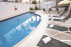 A swimming pool with lounge chairs and umbrellas. - Verona Hplus Long Stay (Lago Norte)