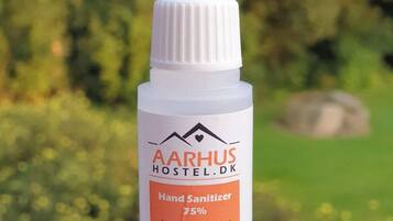 Een fles handdesinfectiemiddel met een etiket voor AARHUS HOSTEL.DK.