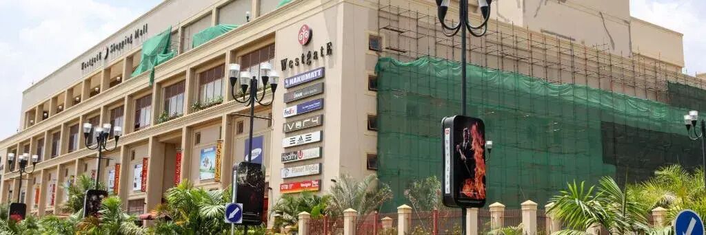 A building with multiple storefronts, including a Westgate Shopping Mall sign.