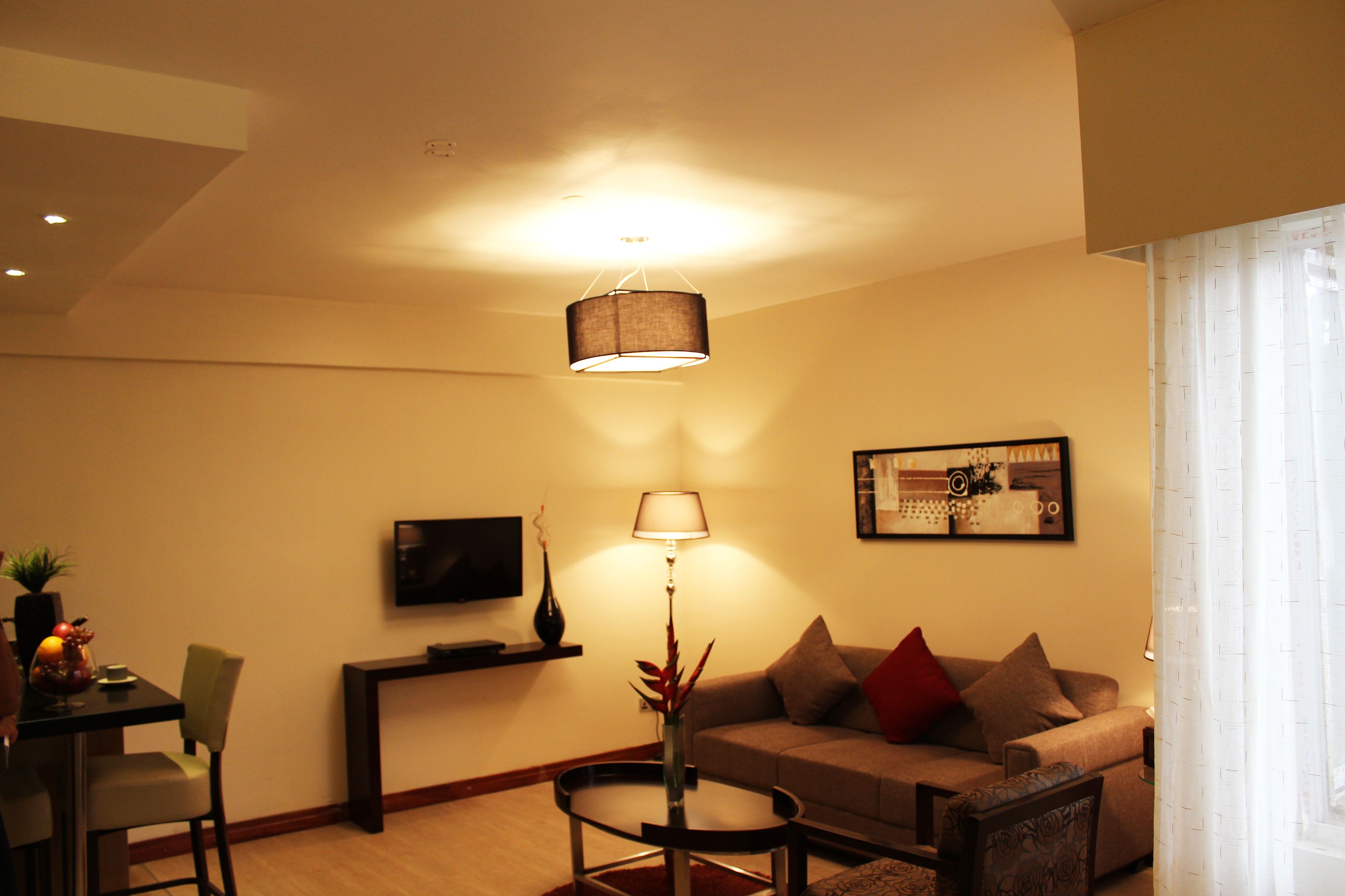 A living room with a sofa, a coffee table, a TV, and a lamp.