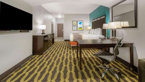 Une chambre d’hôtel équipée d’un lit, d’un bureau, d’une chaise et d’un téléviseur.