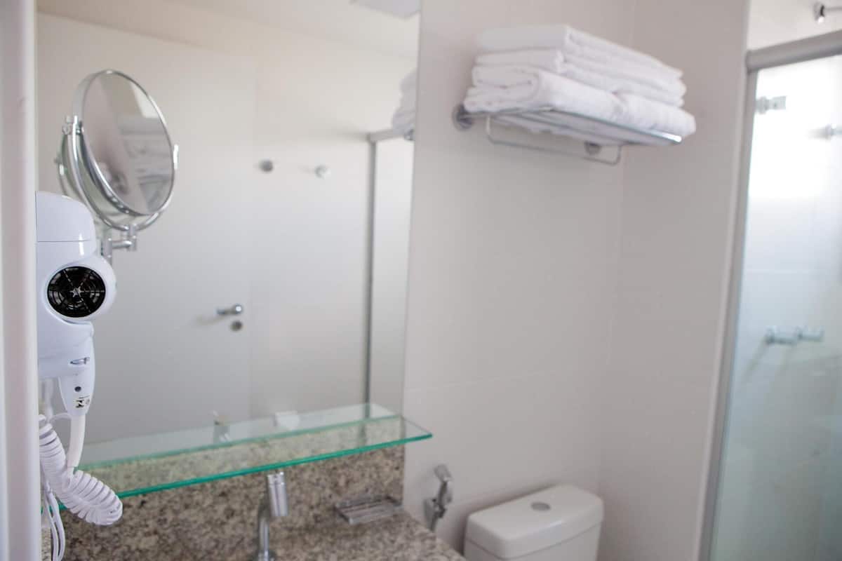 Badkamer | Een douche, een haardroger, handdoeken