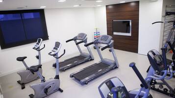 A gym with treadmills, elliptical machines, and a stationary bike.