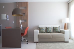 Uma sala de estar moderna com sofá, mesa de jantar e luminária pendente.