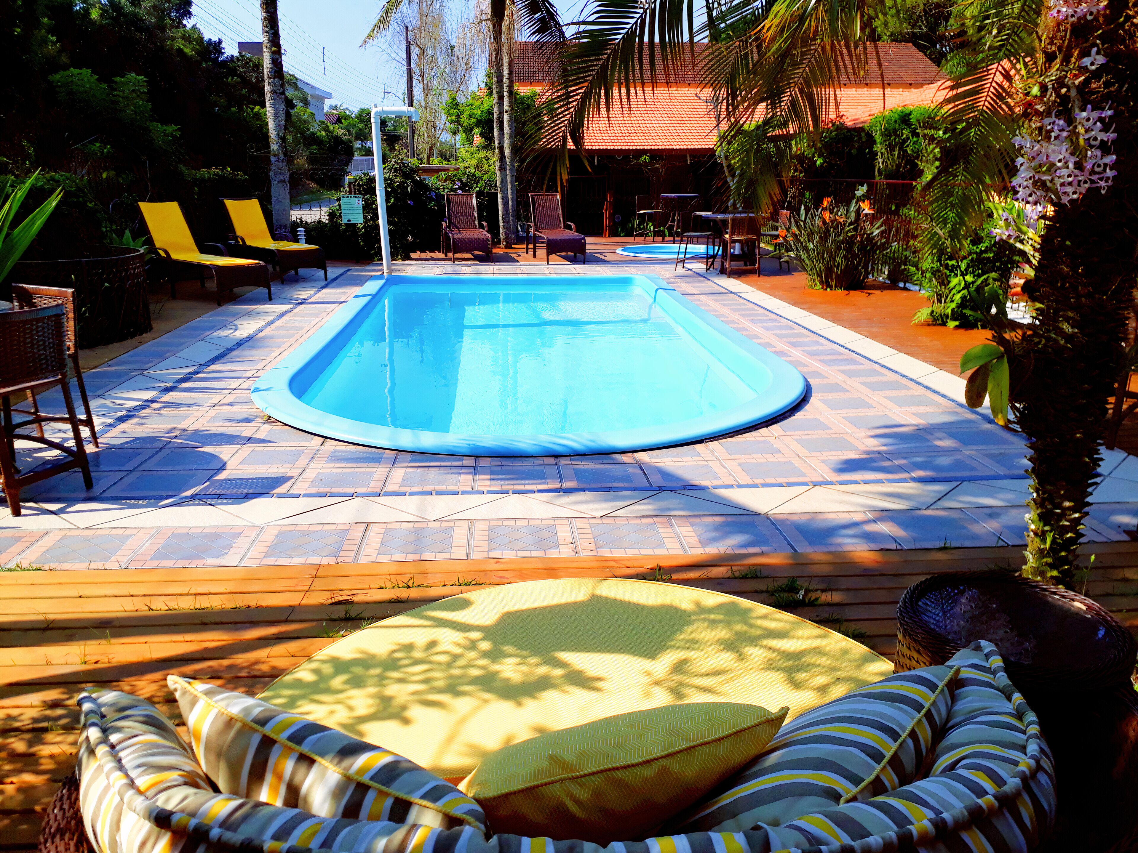 A swimming pool surrounded by lounge chairs and a sunbed.