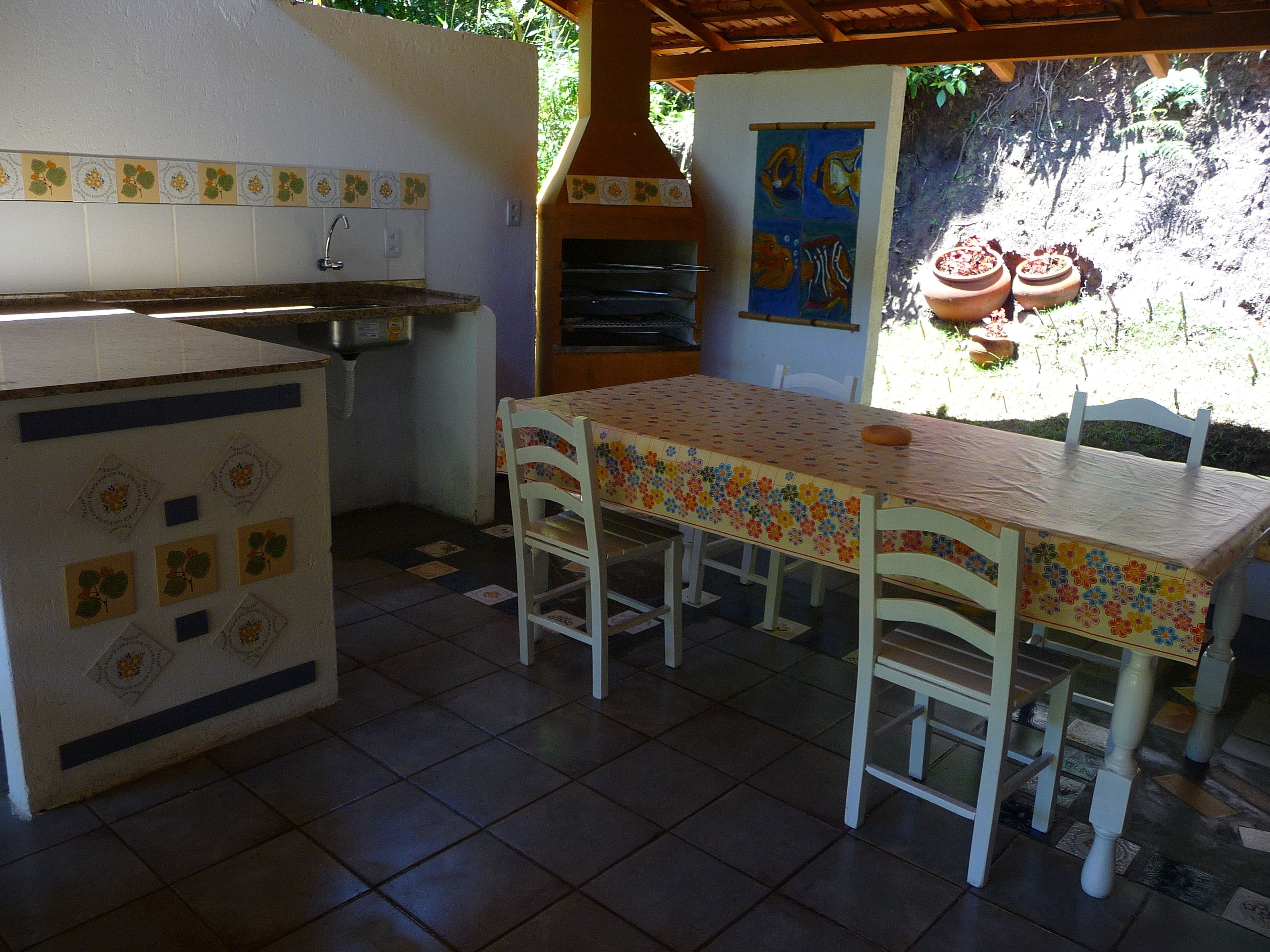 Une cuisine équipée d’un évier, d’une table avec des chaises et d’un mur décoratif.