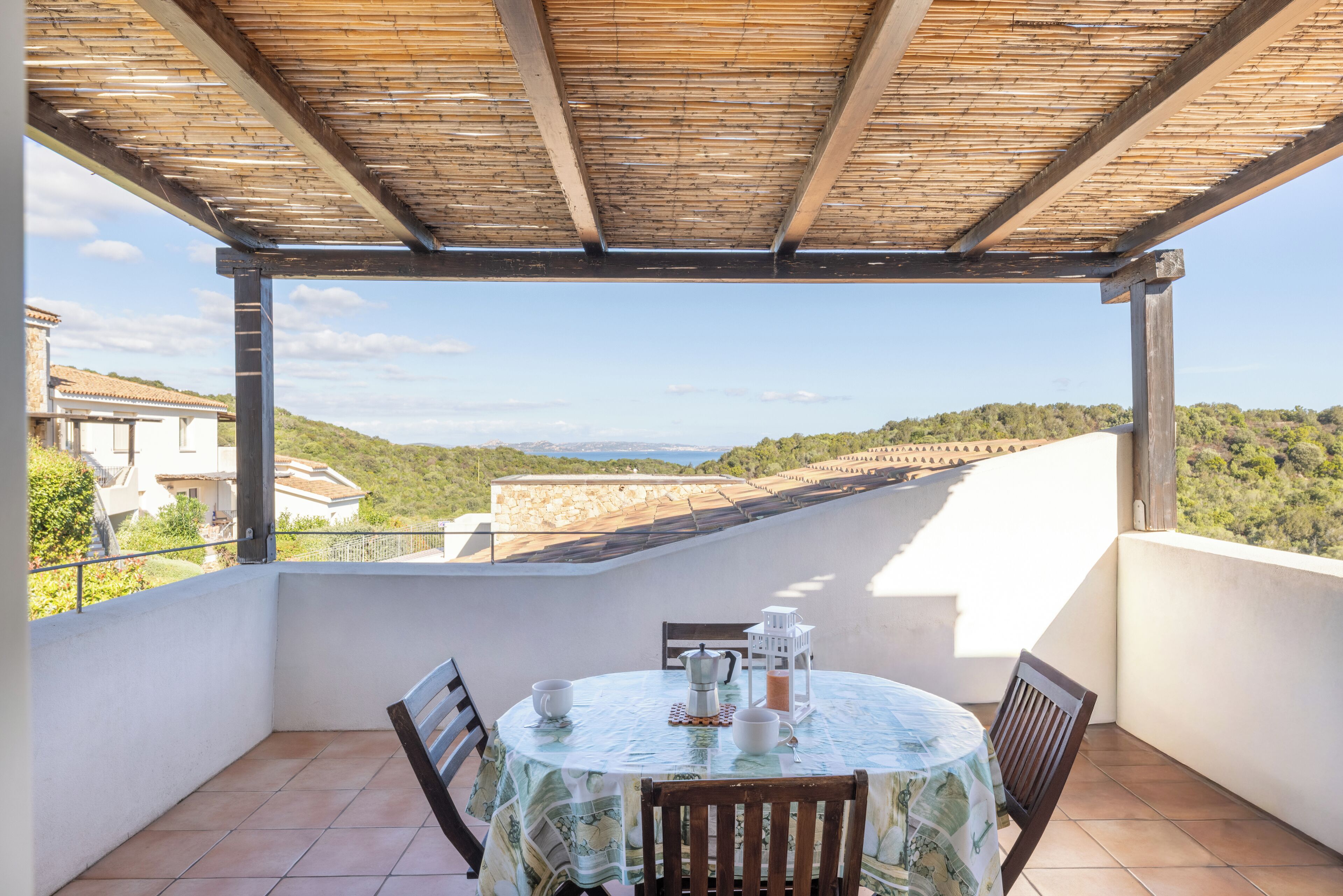 Une terrasse extérieure couverte, avec une table dressée pour deux, offrant une vue sur un paysage magnifique.