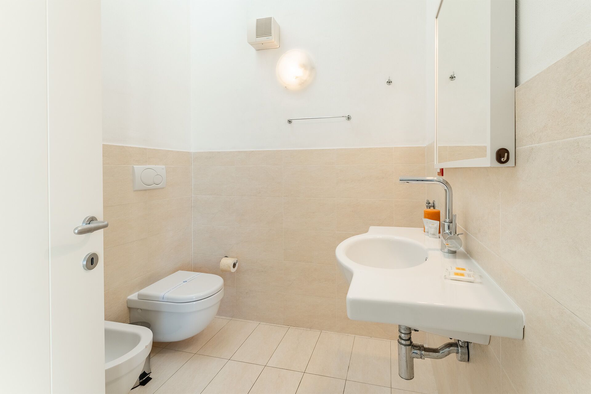 Un baño pequeño y moderno con inodoro, bidé y lavabo.