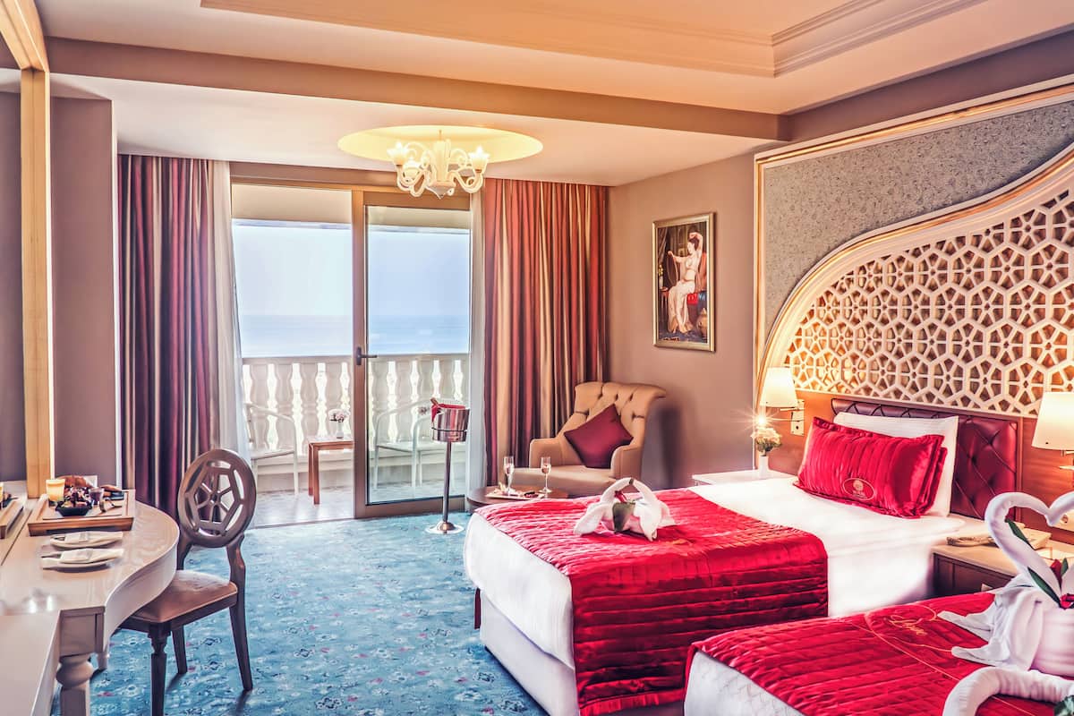 Una habitación de hotel con una cama grande, un escritorio, una silla y un balcón con vistas.