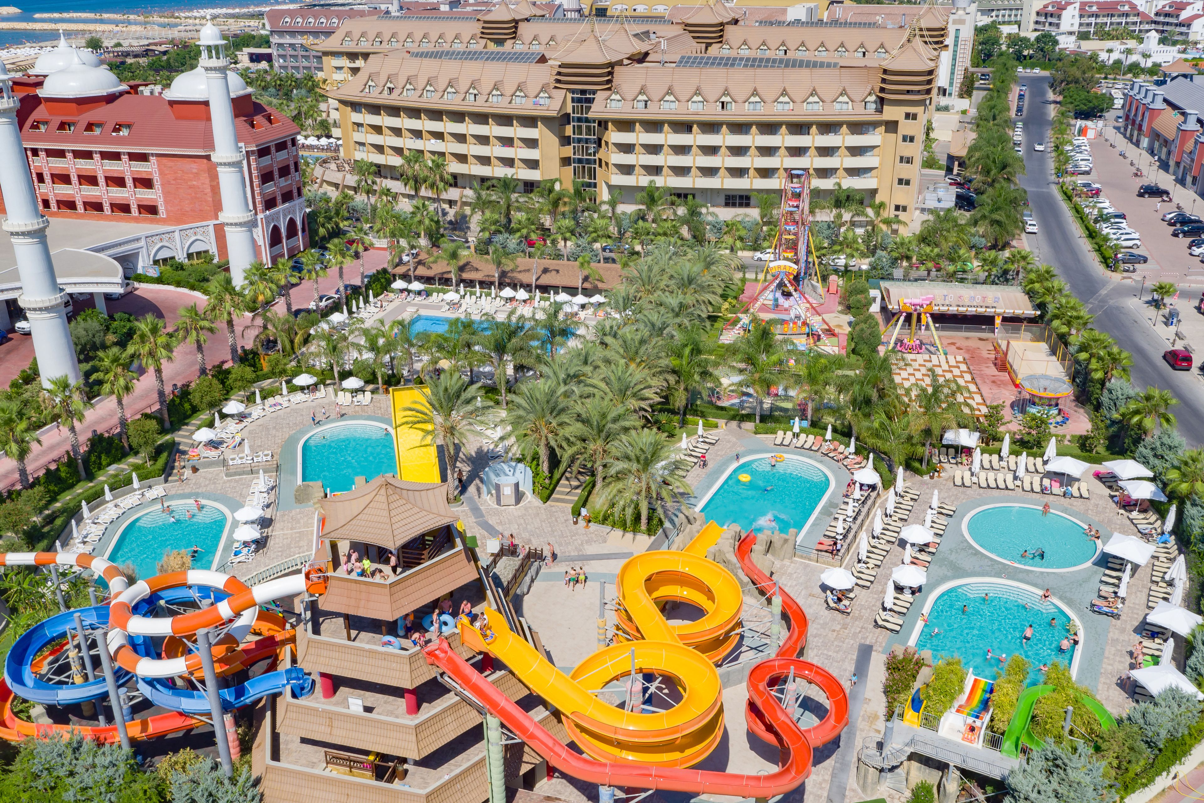 Un complejo turístico con varias piscinas, toboganes acuáticos y un gran edificio de hotel.