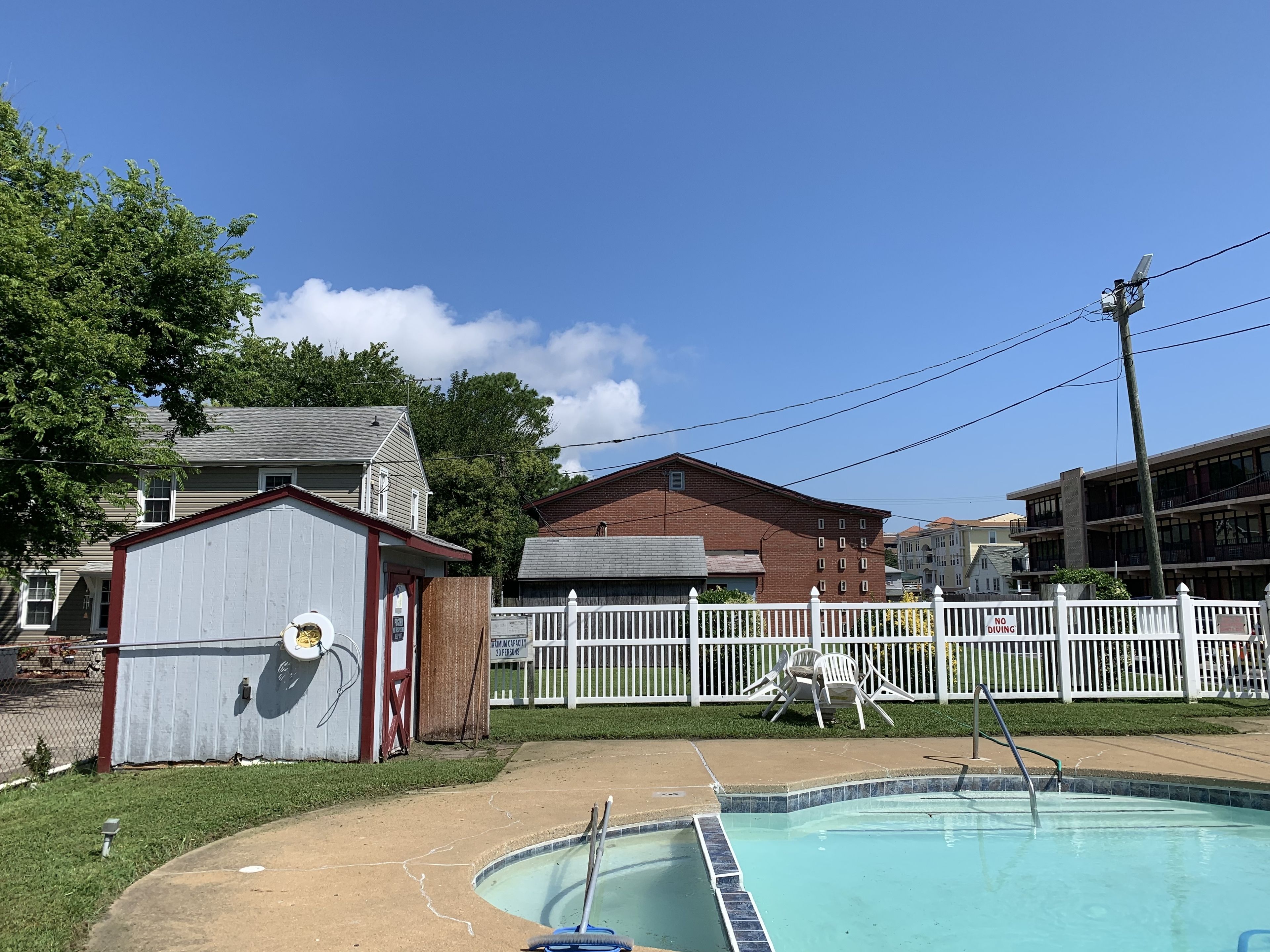 Un quartier résidentiel doté d’une piscine, d’une cour clôturée et d’un petit abri de jardin.