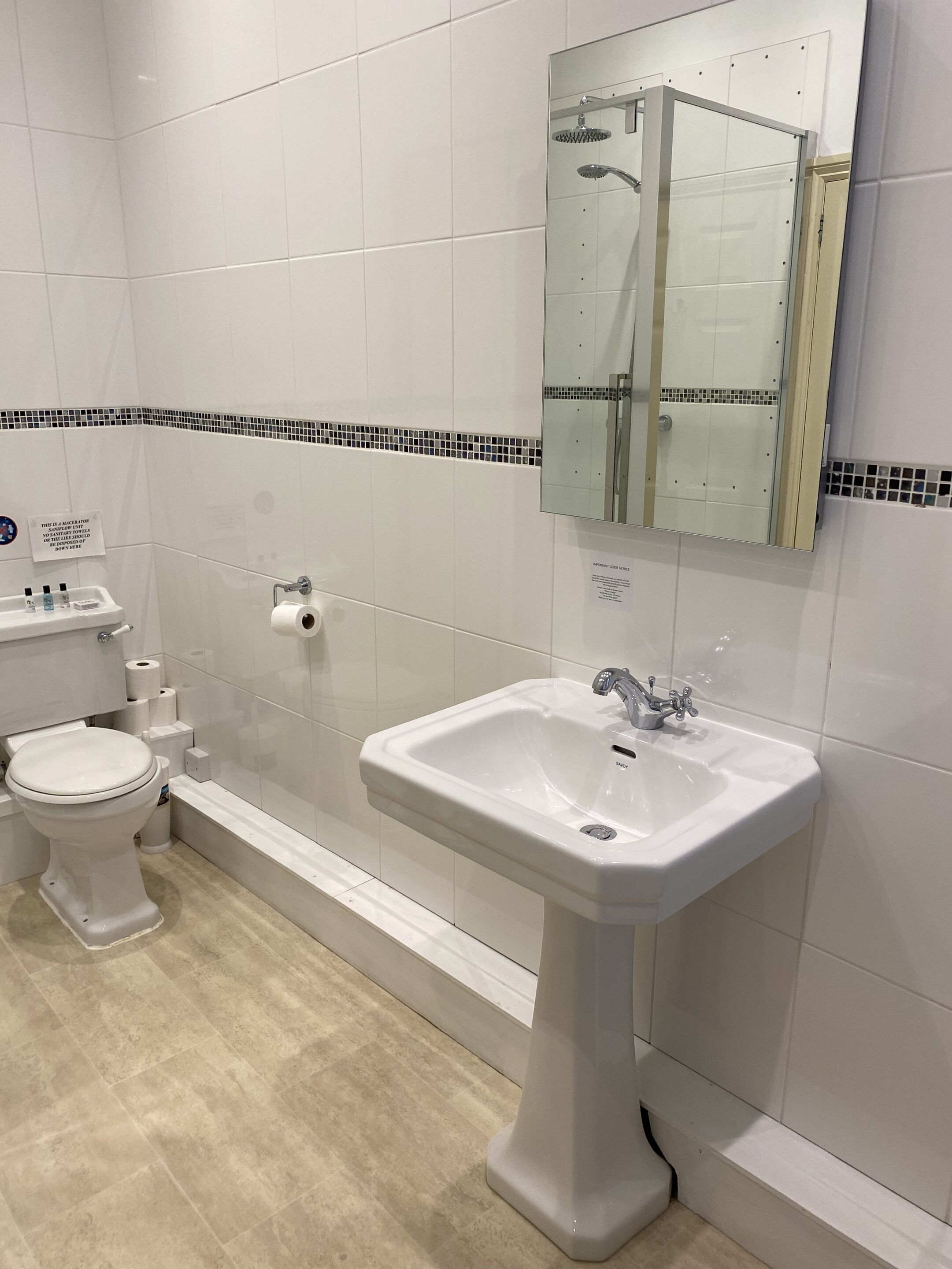 A bathroom with a toilet, sink, and shower.