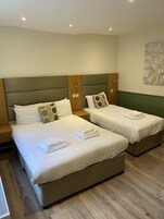 Habitación triple familiar, baño privado | Escritorio, cunas (de pago), wifi gratis y ropa de cama