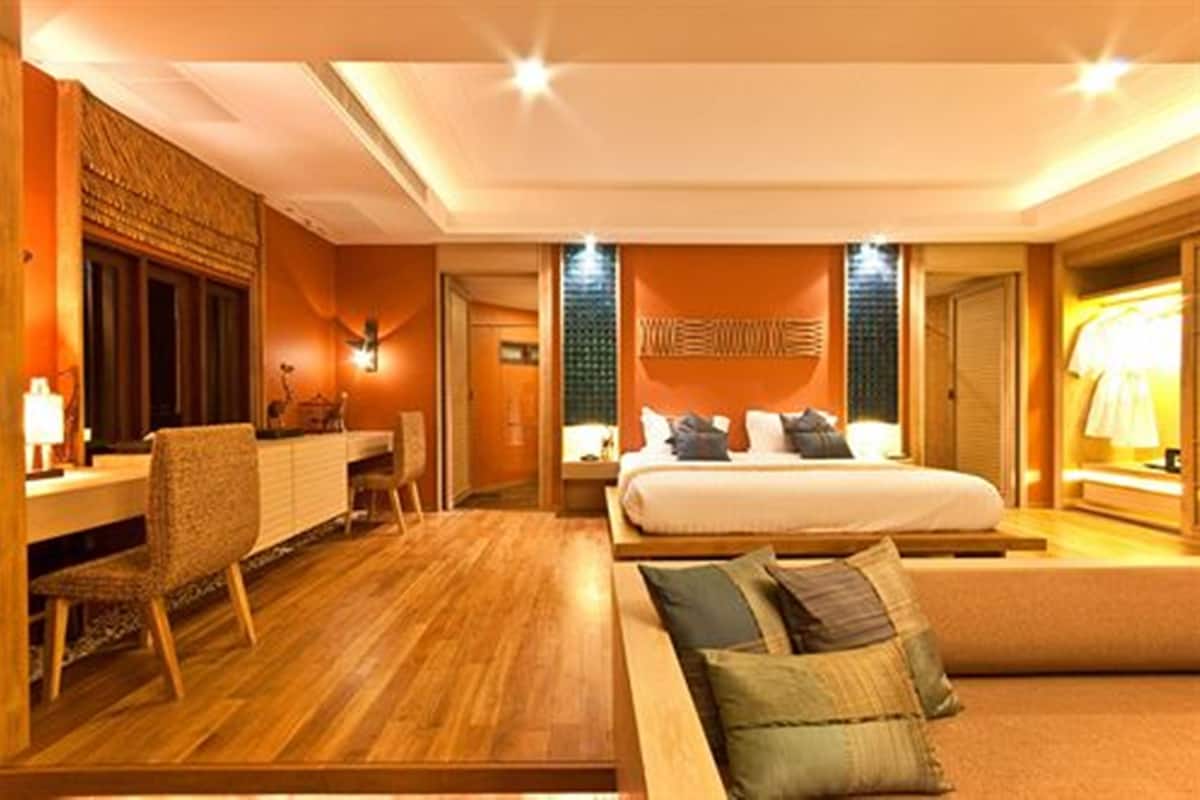 A hotel room with a bed, a desk, a chair, and a wardrobe.