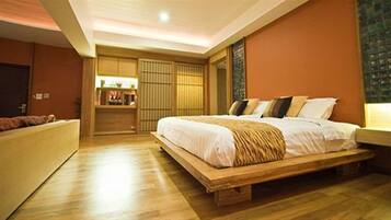 Une chambre avec un grand lit, un plancher en bois, une armoire intégrée et une table de chevet.