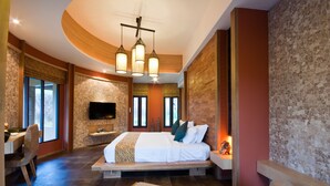 A modern bedroom with a large bed, a television, and a dining area. - Montis Resort (Pai)