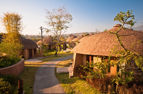 A row of dome-shaped huts with a paved path leading through them. - Montis Resort (Pai)