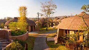 A series of dome-shaped huts with a pathway leading through them, surrounded by greenery.