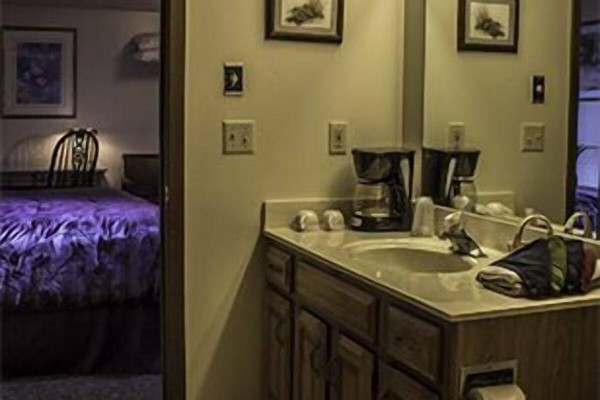 A hotel bathroom with a sink, mirror, and lights.