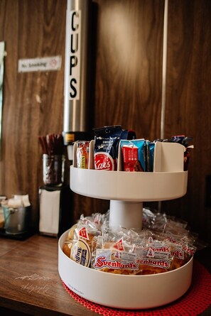 A snack display with various packaged snacks and a sign indicating 'No Smoking'. - American Classic Inn (Salida)