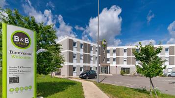 Une enseigne indiquant un hôtel de type « chambre d’hôtes », avec un message d’accueil, précisant que des chambres sont disponibles pour une à trois personnes et qu’il y a également une chambre familiale.