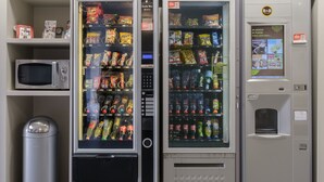 A vending machine area with snack and drink options, a microwave, and a trash bin. - B&B HOTEL Romilly-sur-Seine (Maizieres-la-Grande-Paroisse)