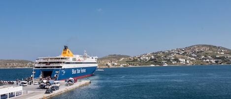 A ferry docked at a pier with a clear view of the surrounding landscape.