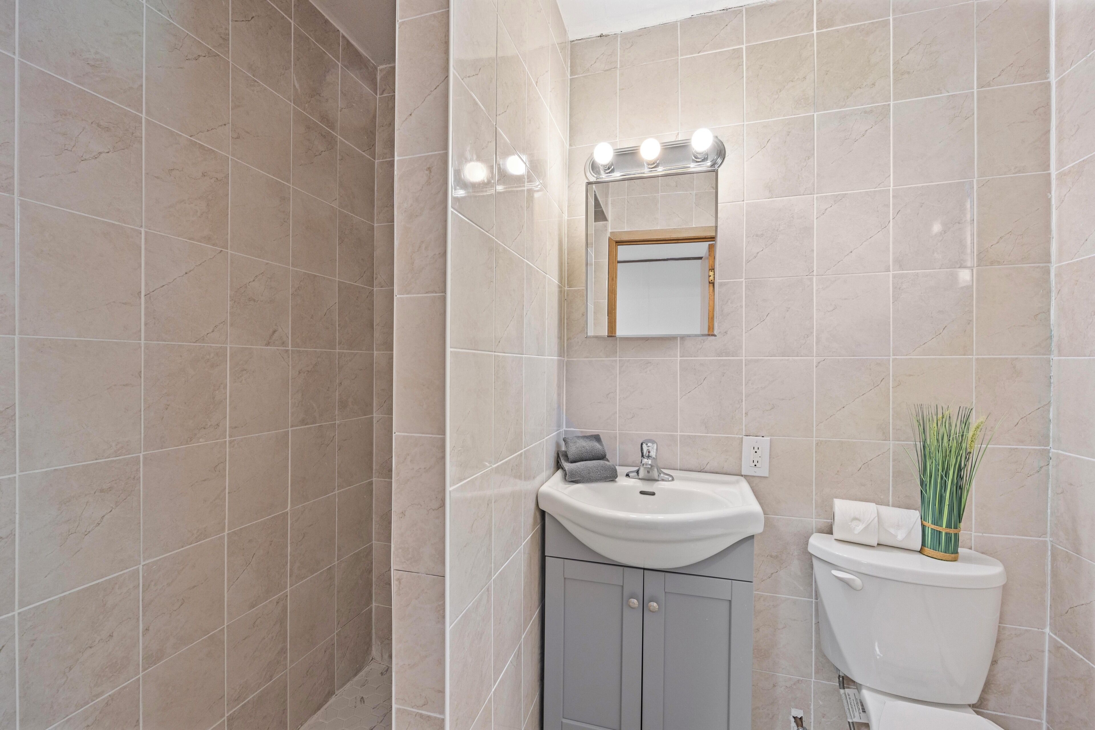 A bathroom with a sink, mirror, and toilet.