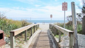 A wooden boardwalk leading to the beach with signs indicating no tents or other shading devices allowed. - The Dunes Towers by Palmetto Vacations (Myrtle Beach)