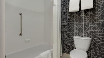 Un baño con bañera, inodoro y zona de ducha.