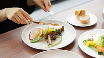 Una mesa de comedor con platos de comida, un tenedor y un cuchillo.