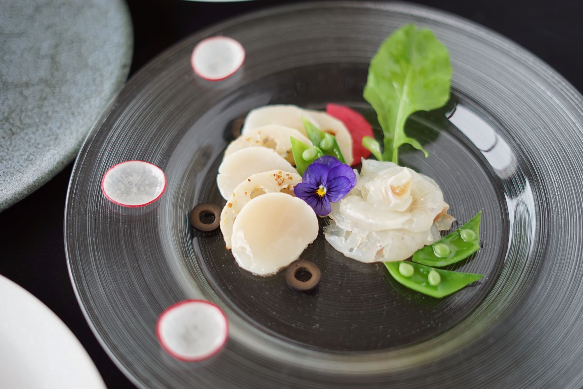 Un plato con diferentes alimentos y una flor.