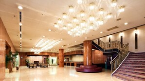 A spacious lobby with a grand staircase, a reception desk, and a chandelier. - Hotel Marroad Tsukuba (Tsuchiura)