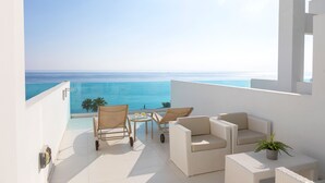 A balcony with a view of the sea, wicker furniture, and a small table with a plant. - Vrissaki Beach Hotel (Paralimni)