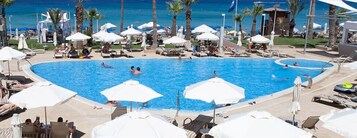 Una piscina cubierta, una piscina al aire libre de temporada, sombrillas