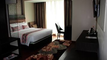 Una habitación de hotel moderna con una cama grande, un escritorio y una silla.