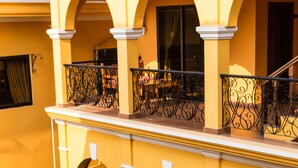 A multi-story yellow building with balconies, arched windows, and a staircase. - Robam Inn (Siem Reap)