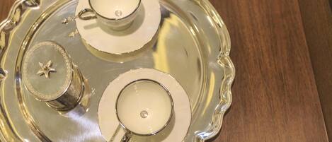 A silver tray with two teacups and a teapot.