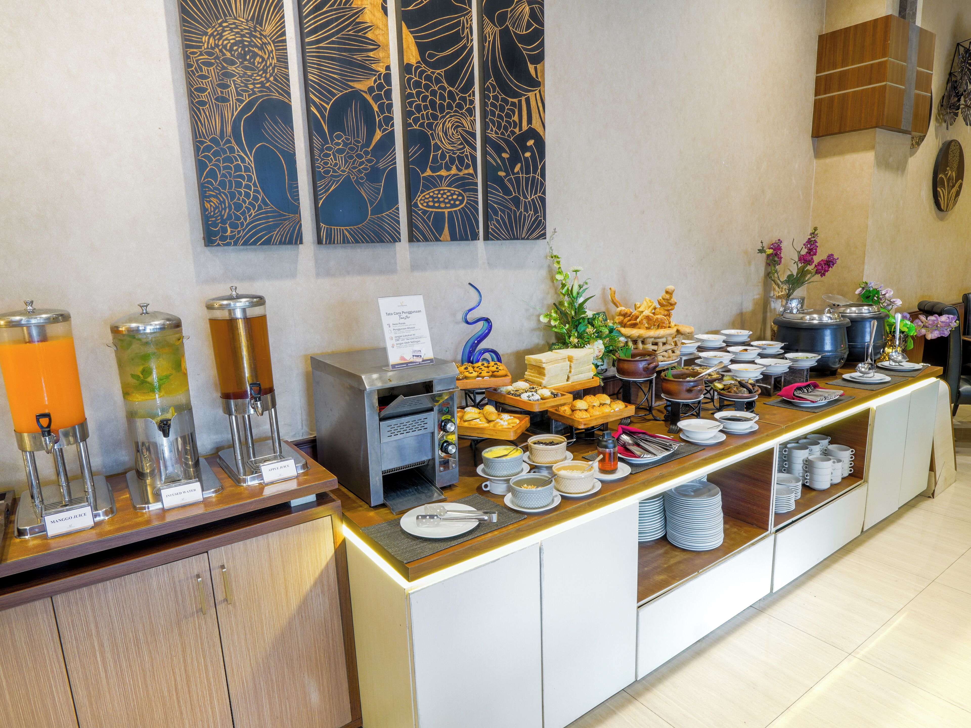 A buffet with various food items, a coffee machine, and a beverage dispenser.