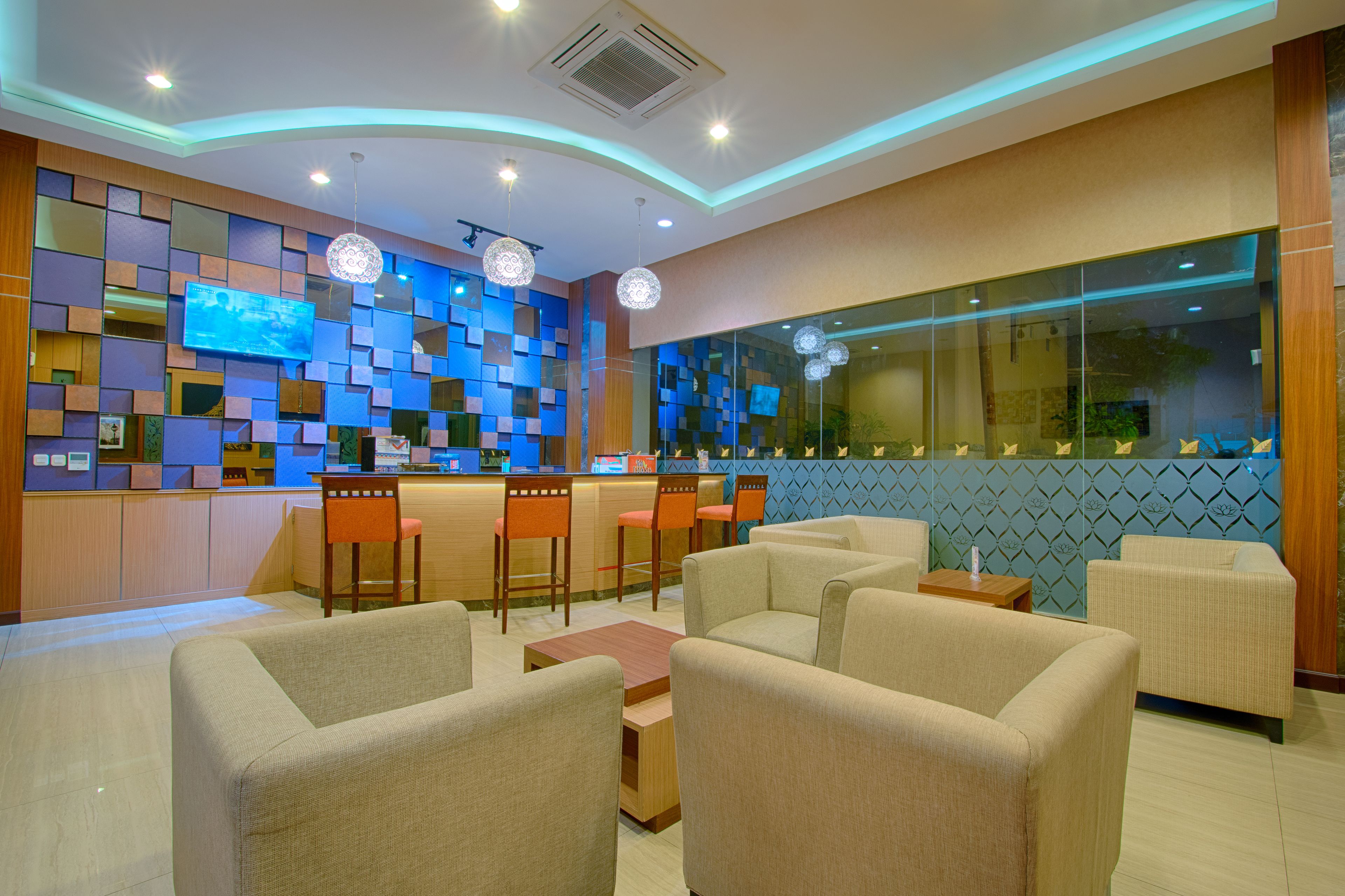 Un moderno vestíbulo de hotel con zona de bar, asientos y un amplio ventanal.